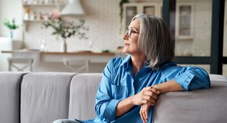 Woman sitting on couch looking out window